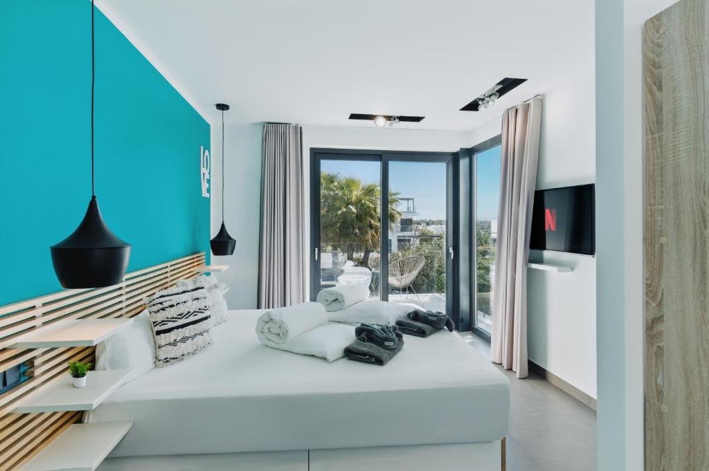 View of a second-floor villa room with a window overlooking the garden, a large bed with handcrafted decorations, a television, and bedroom furniture - Villa Horizont Dreams