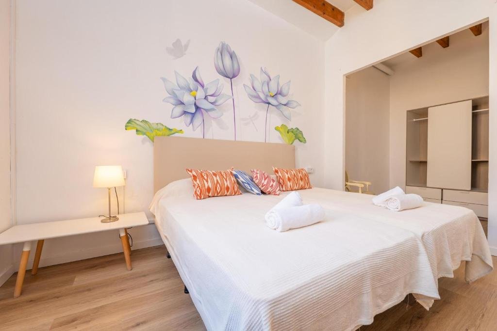 View of a villa room, featuring a large bed, spring-themed handcrafted decorations on the wall, and bedroom furniture.
